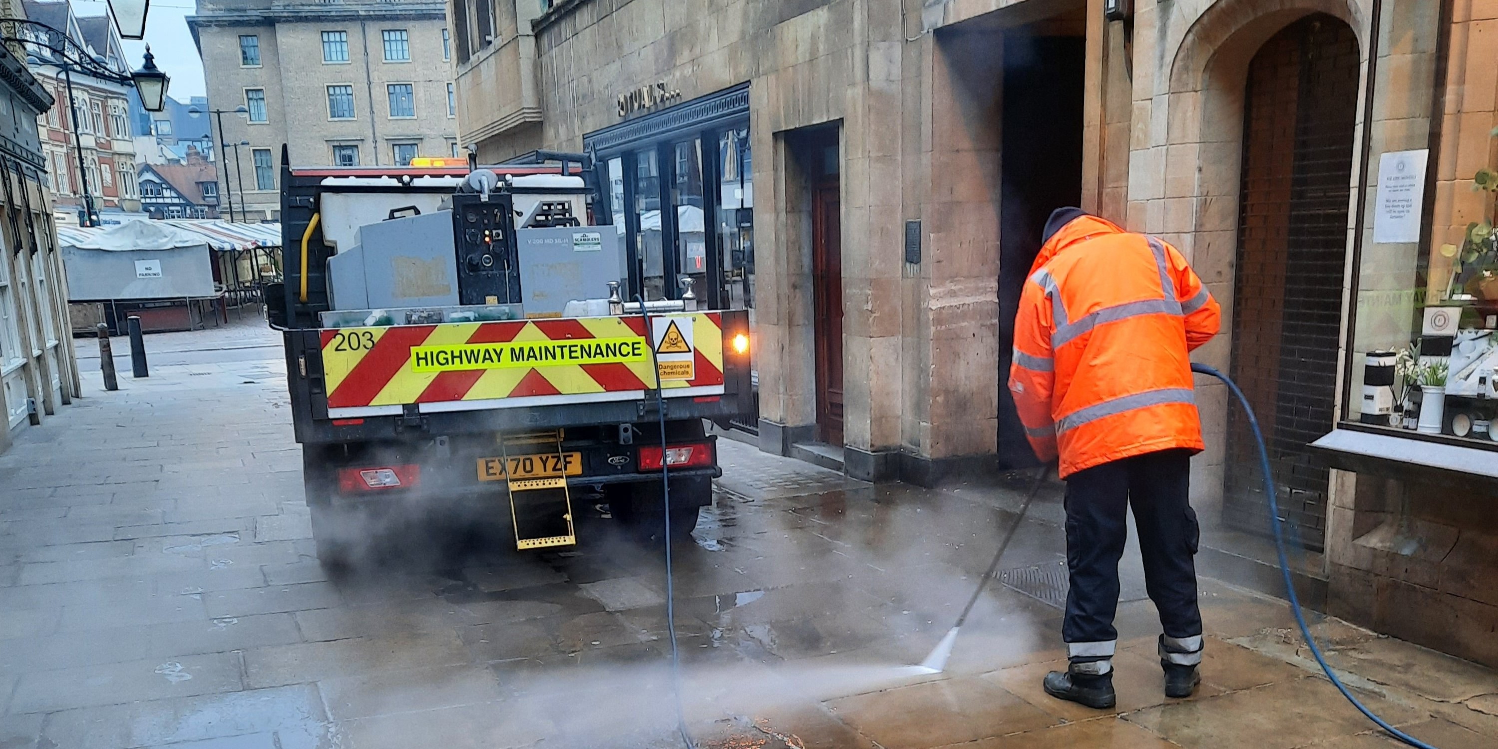 Street cleaner jet washing a street in Cambridge
