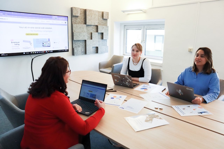 Three women with laptops in a meeting