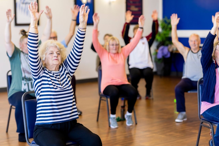 Older people doing chair-based exercise in a class