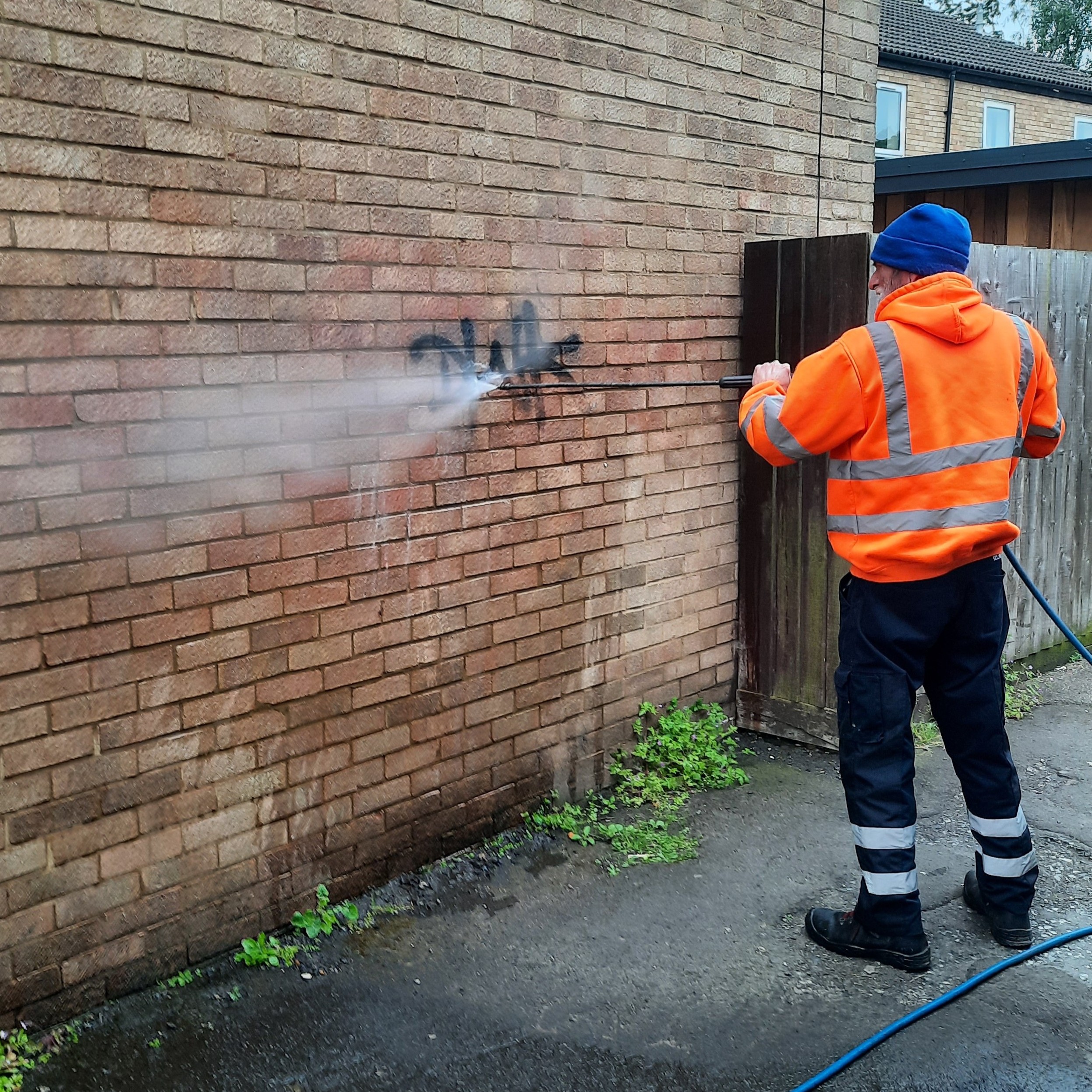 Graffiti on a wall being cleaned