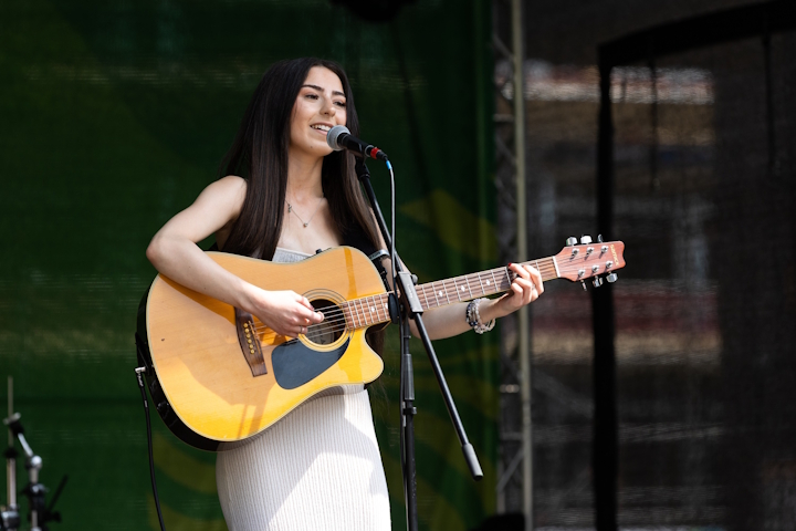 Musician singing and playing the guitar on stage